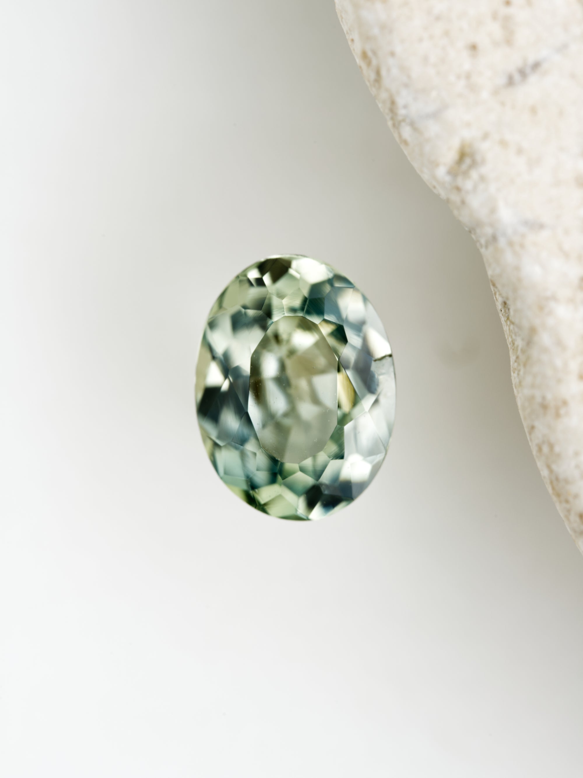 Oval-shaped green gemstone on a white background